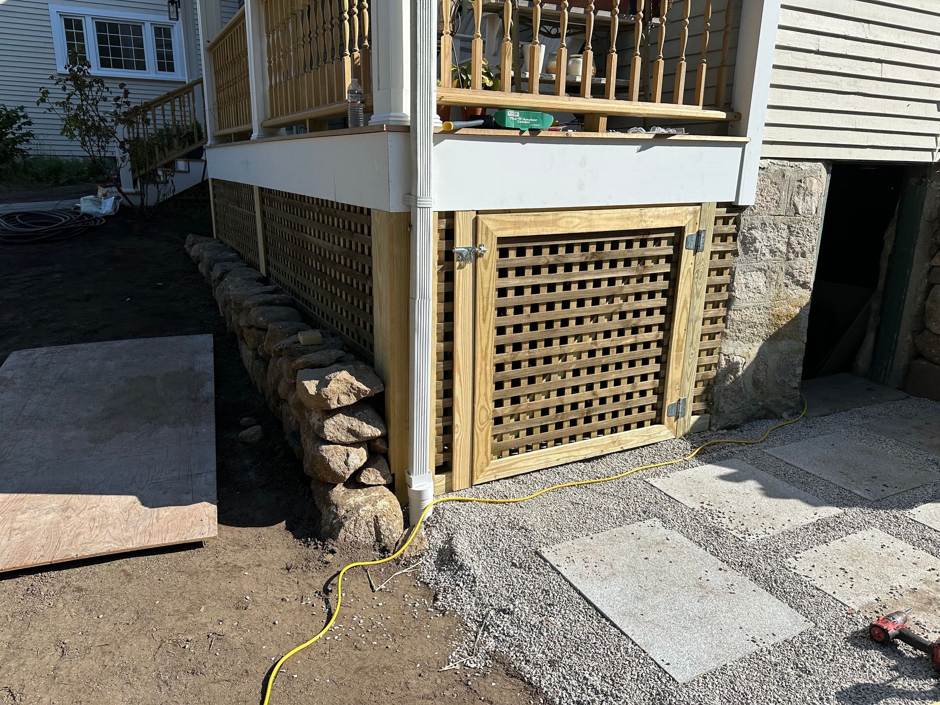 A wooden gate is being installed on the side of a house.