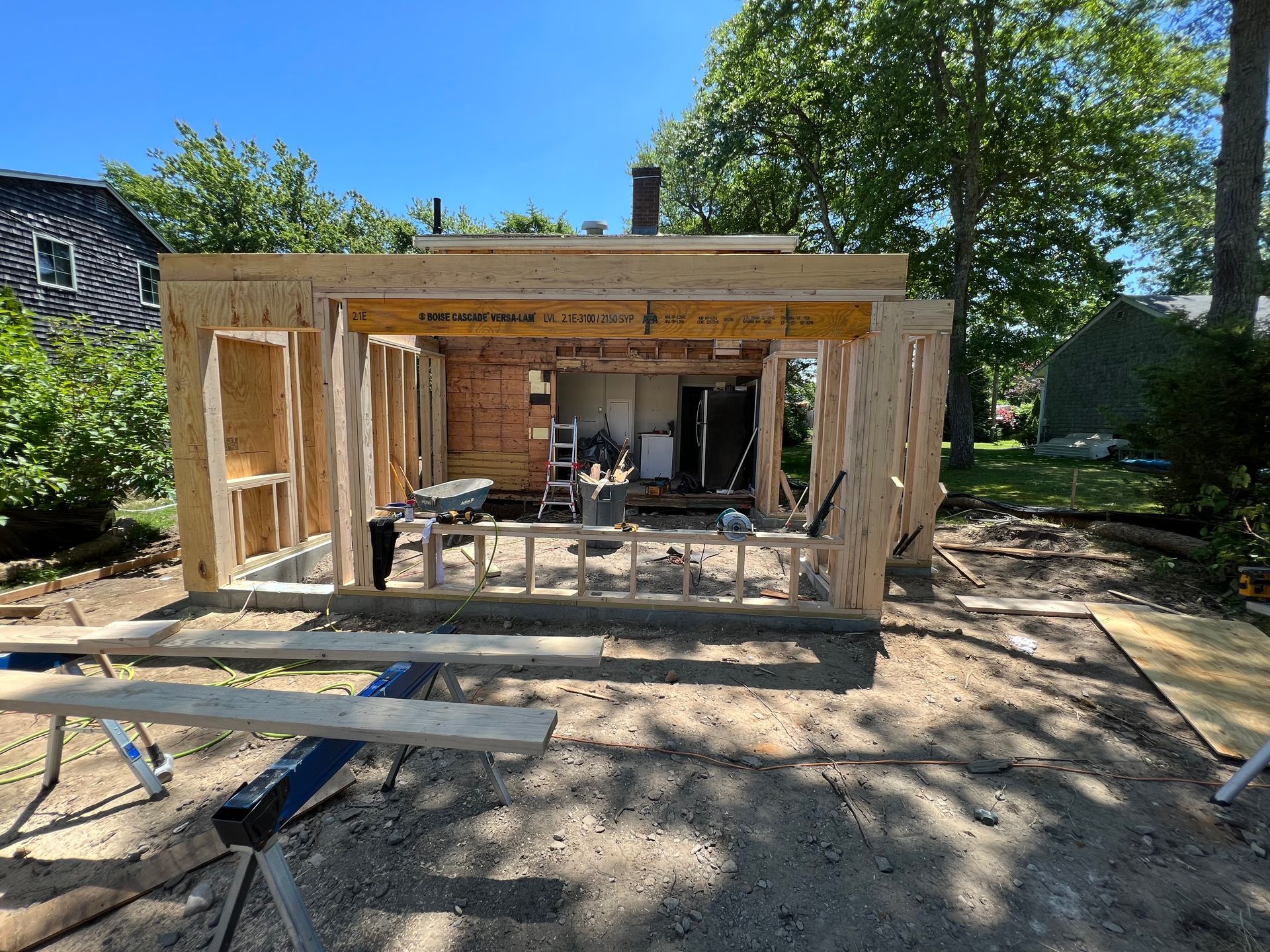 A wooden structure is being built in the backyard of a house.