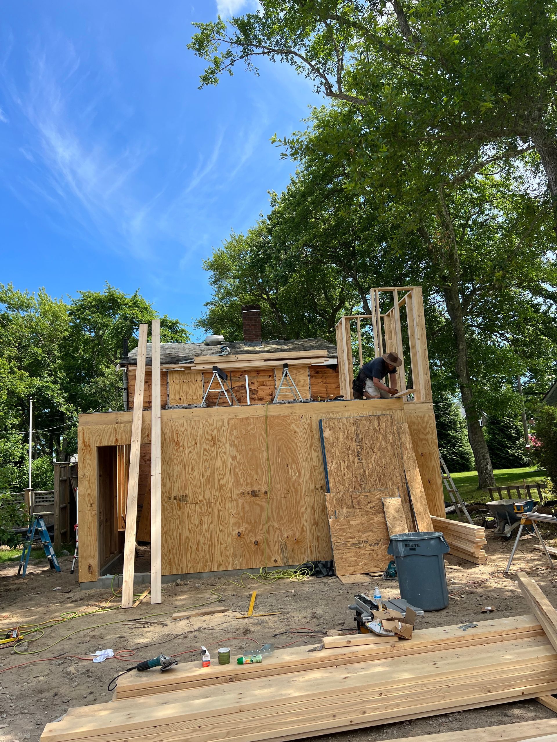 A man is working on the roof of a house under construction.