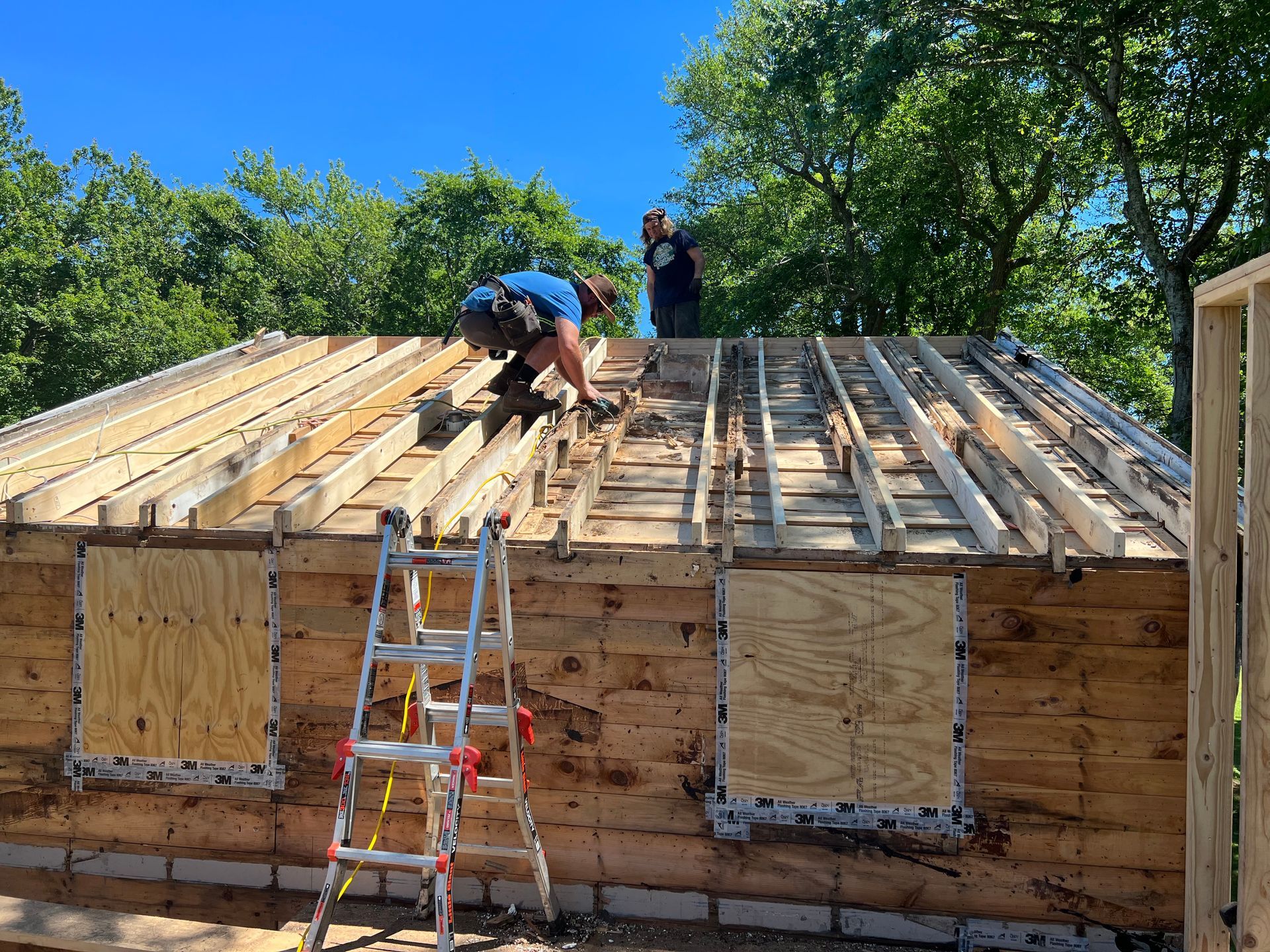 A man is working on the roof of a wooden house.