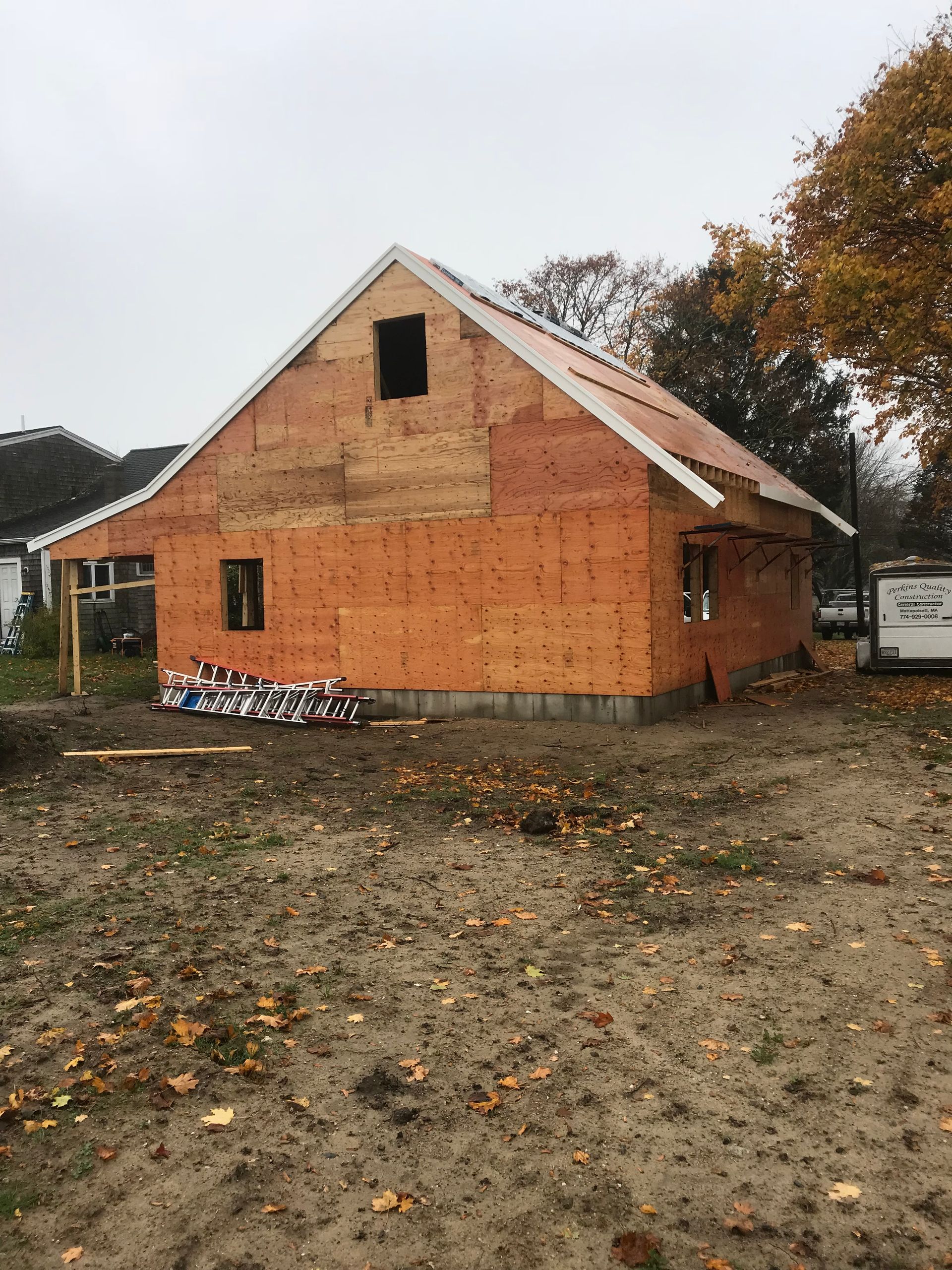 A large orange house is being built in a dirt field.