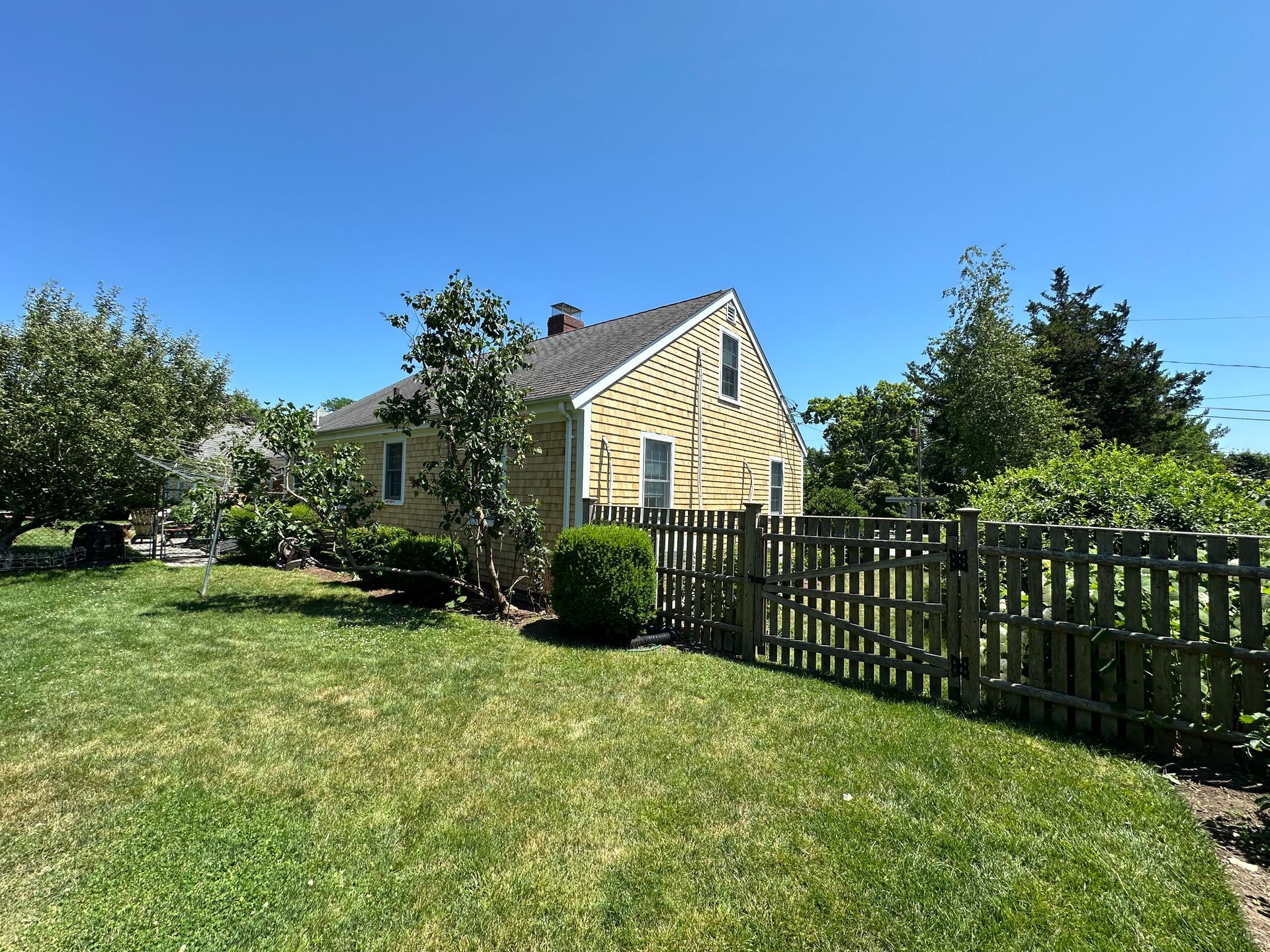 A yellow house with a wooden fence in front of it