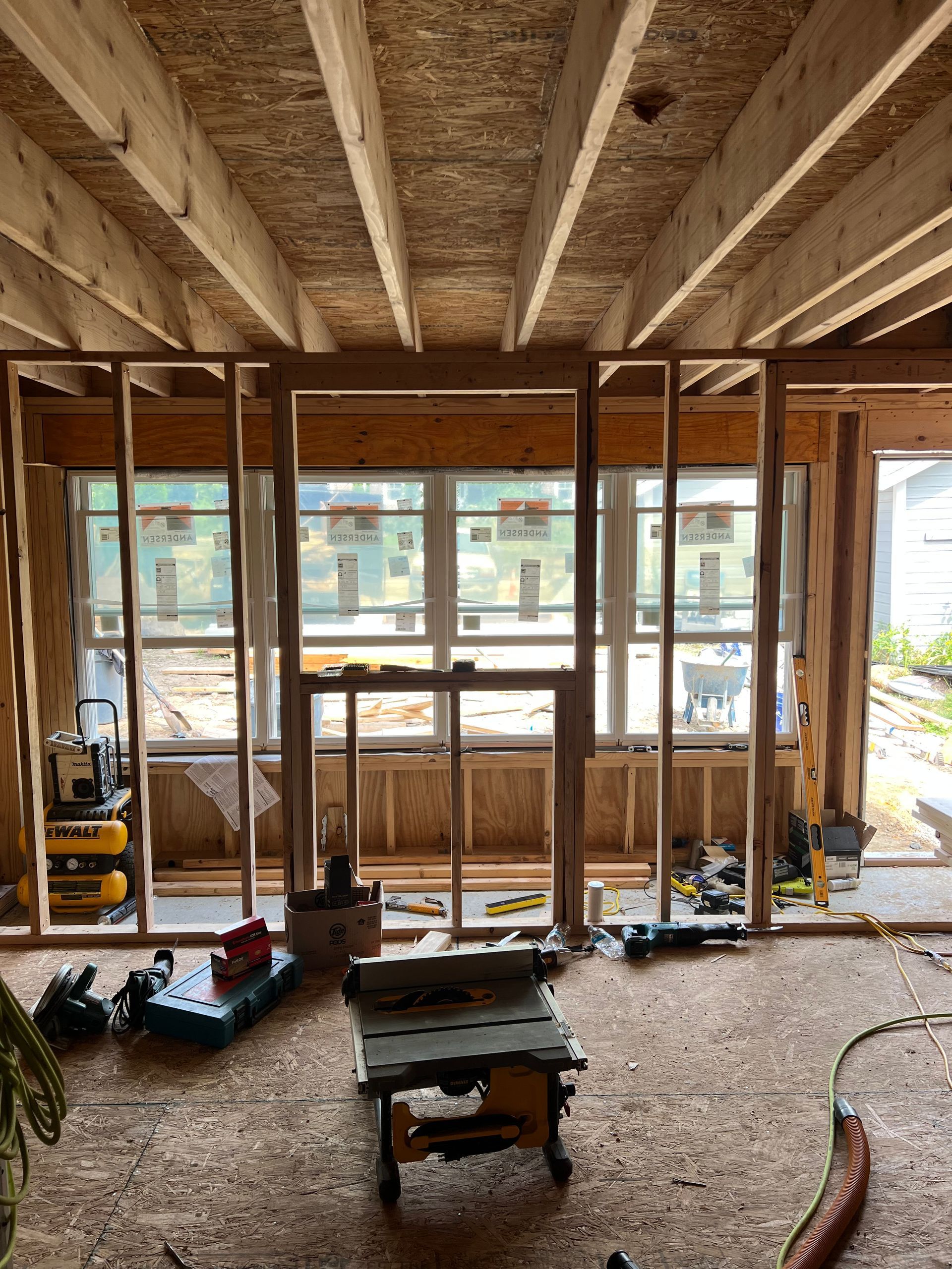 A room under construction with a table and tools on the floor.