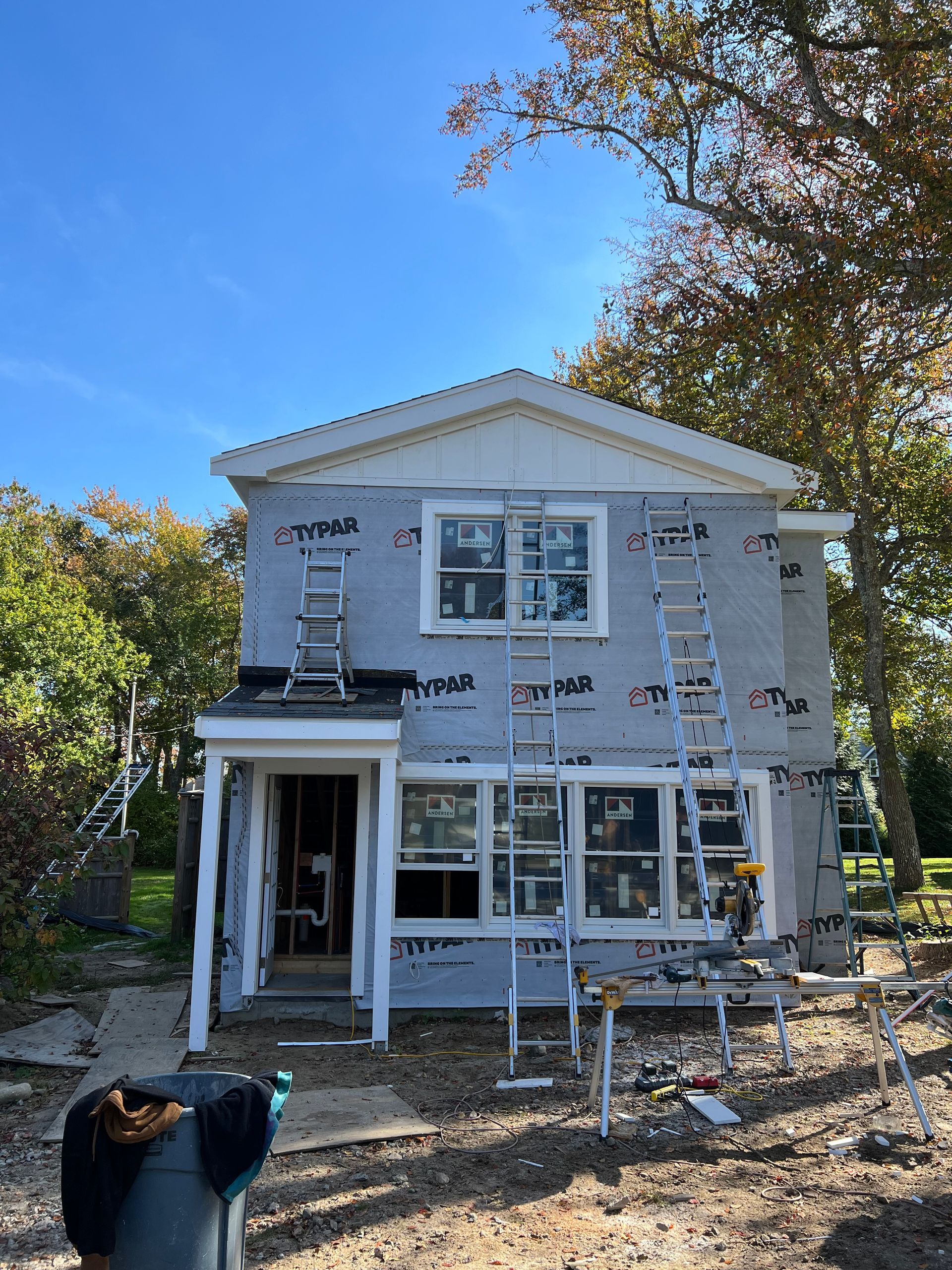 A woman is standing in front of a house that is being remodeled