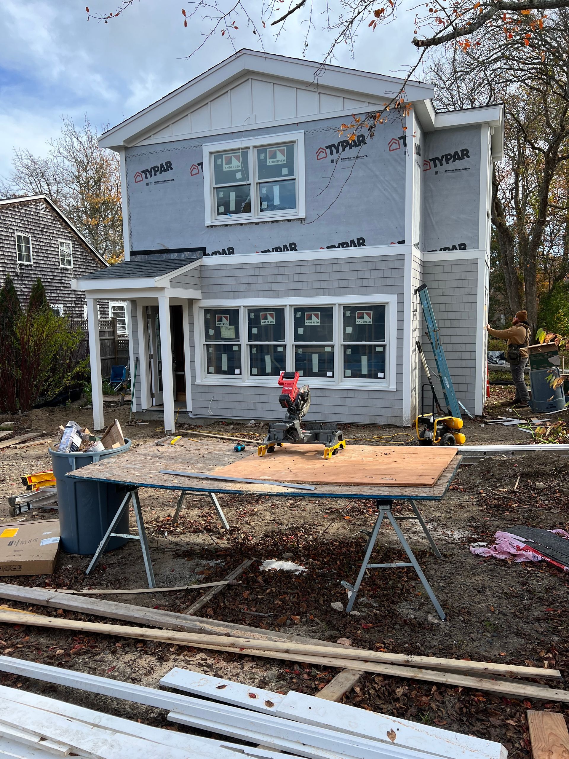 A house is being remodeled with a table in front of it.