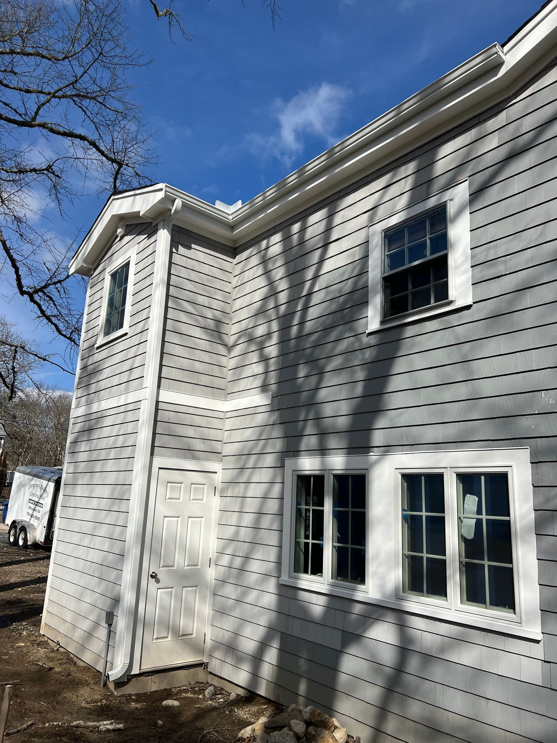 A large white house with a lot of windows and a blue sky in the background.