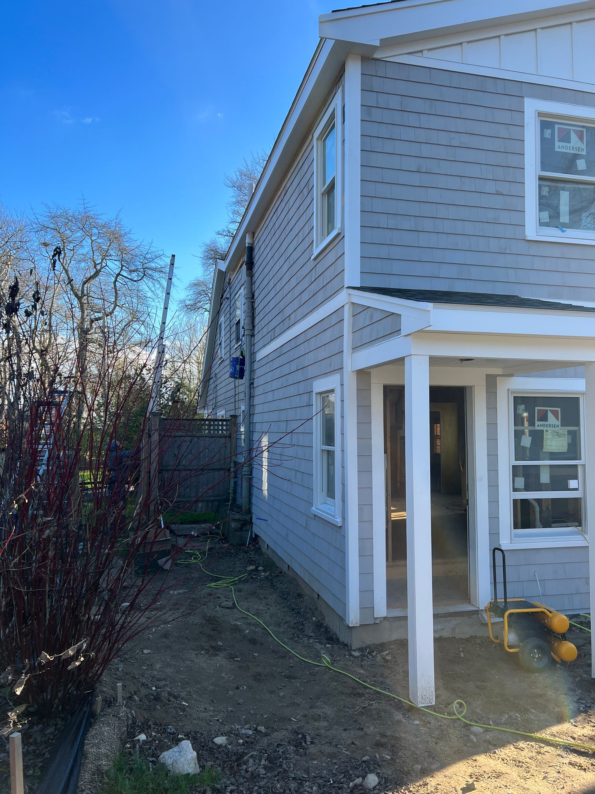 A house with a porch and a blue sky in the background