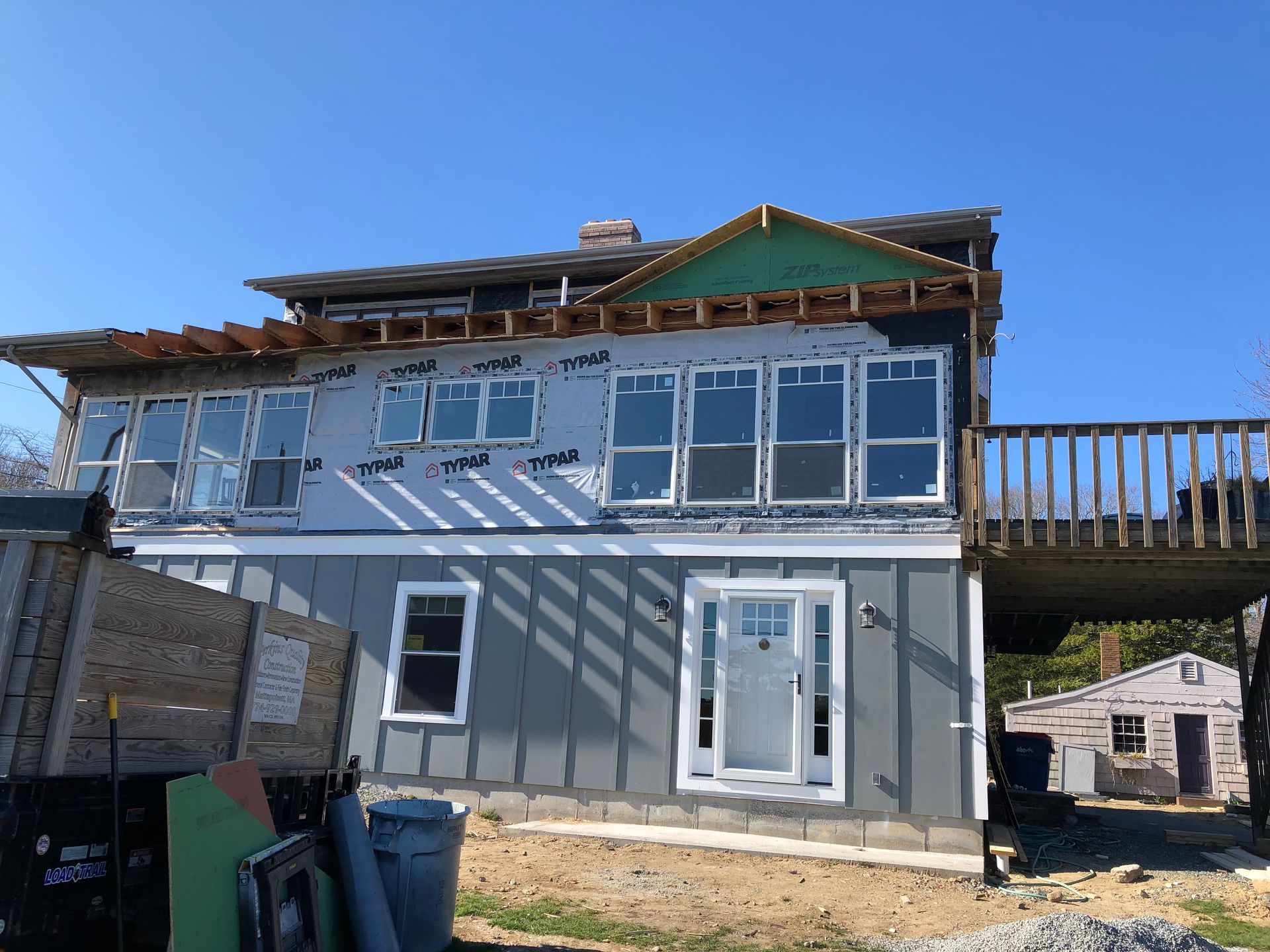 A house is being built with a lot of windows and a deck.