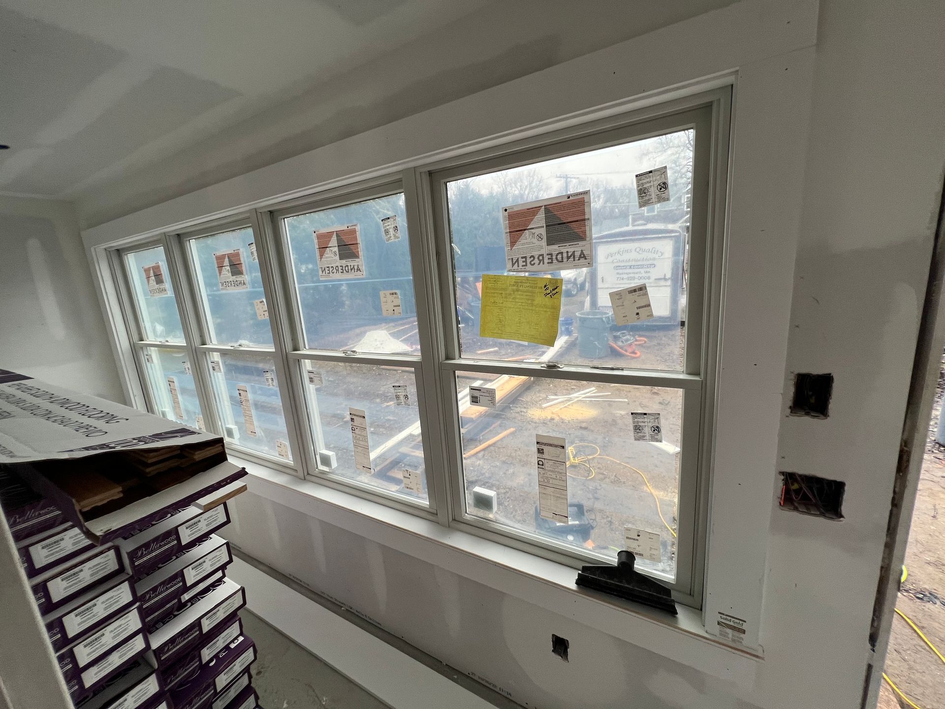 A room with a lot of windows and a stack of flooring.