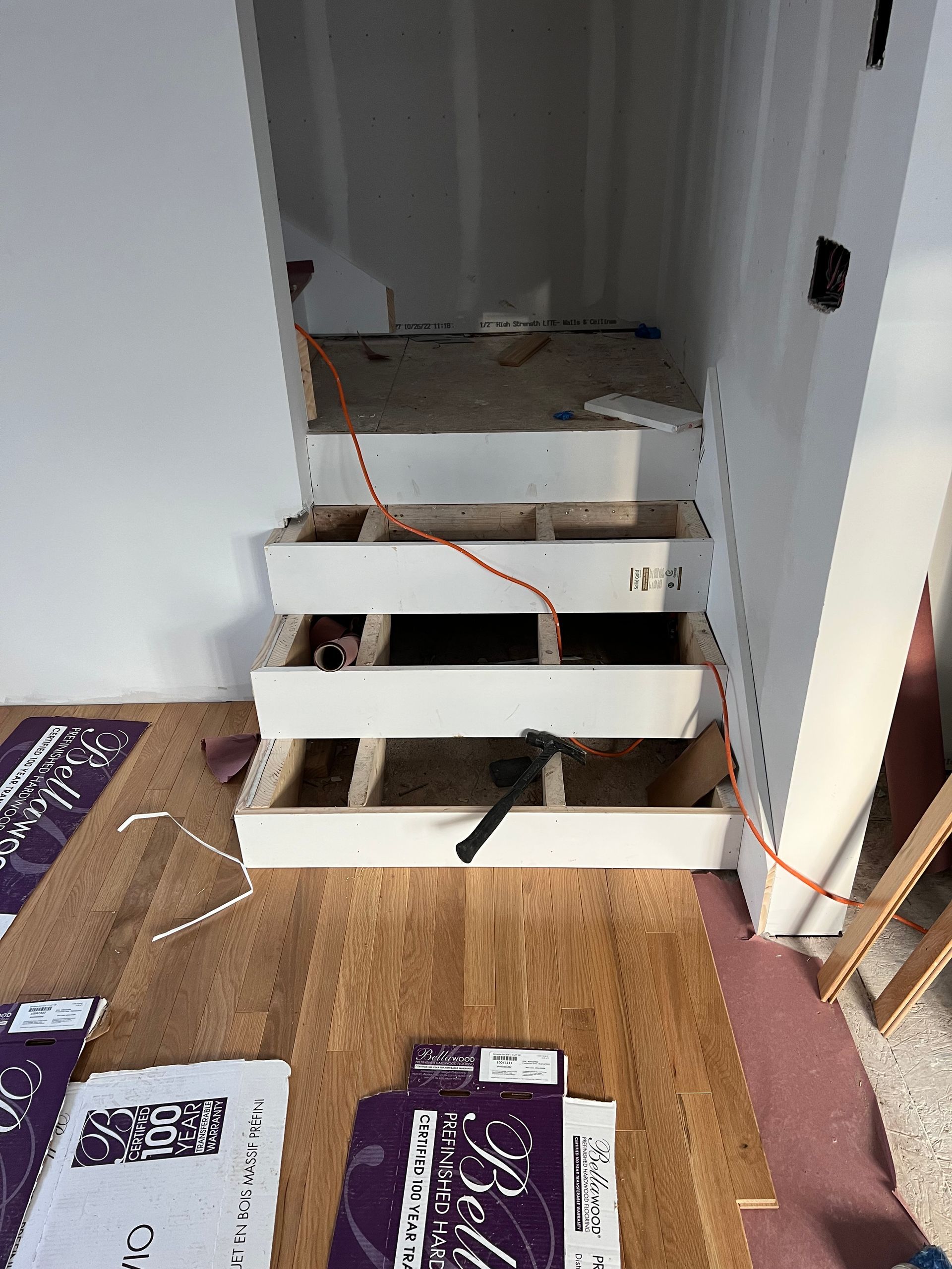 A wooden staircase is being built in a room.