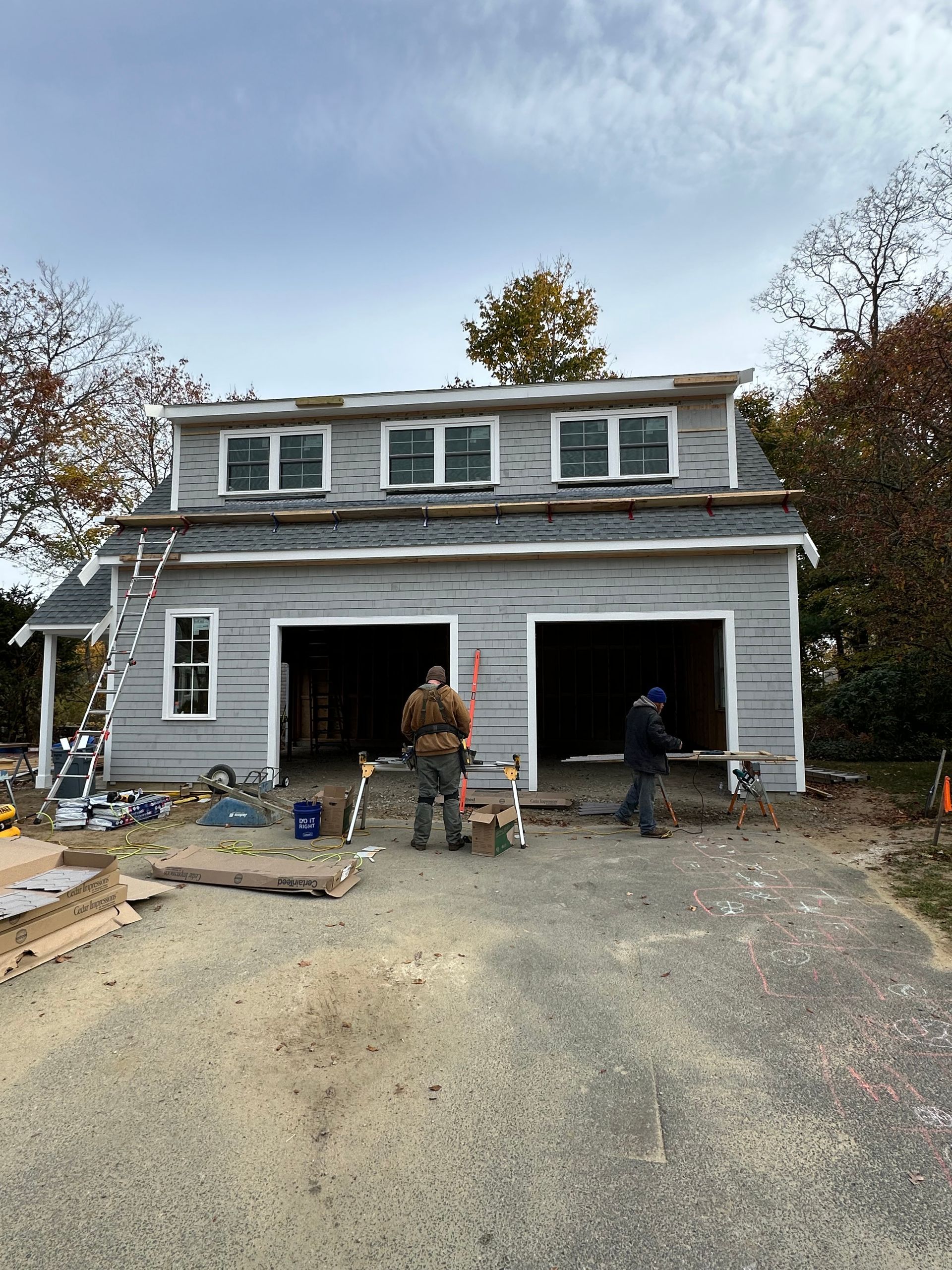 A man is standing in front of a garage under construction.