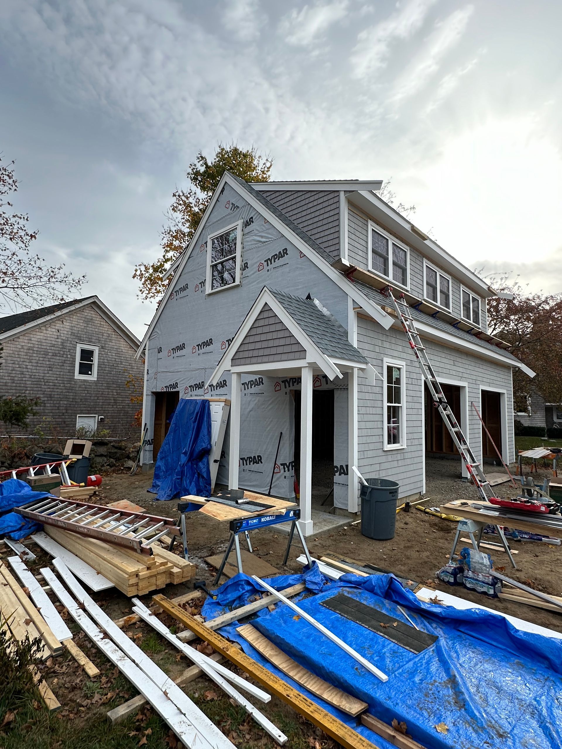 A house is being built with a lot of wood in front of it.