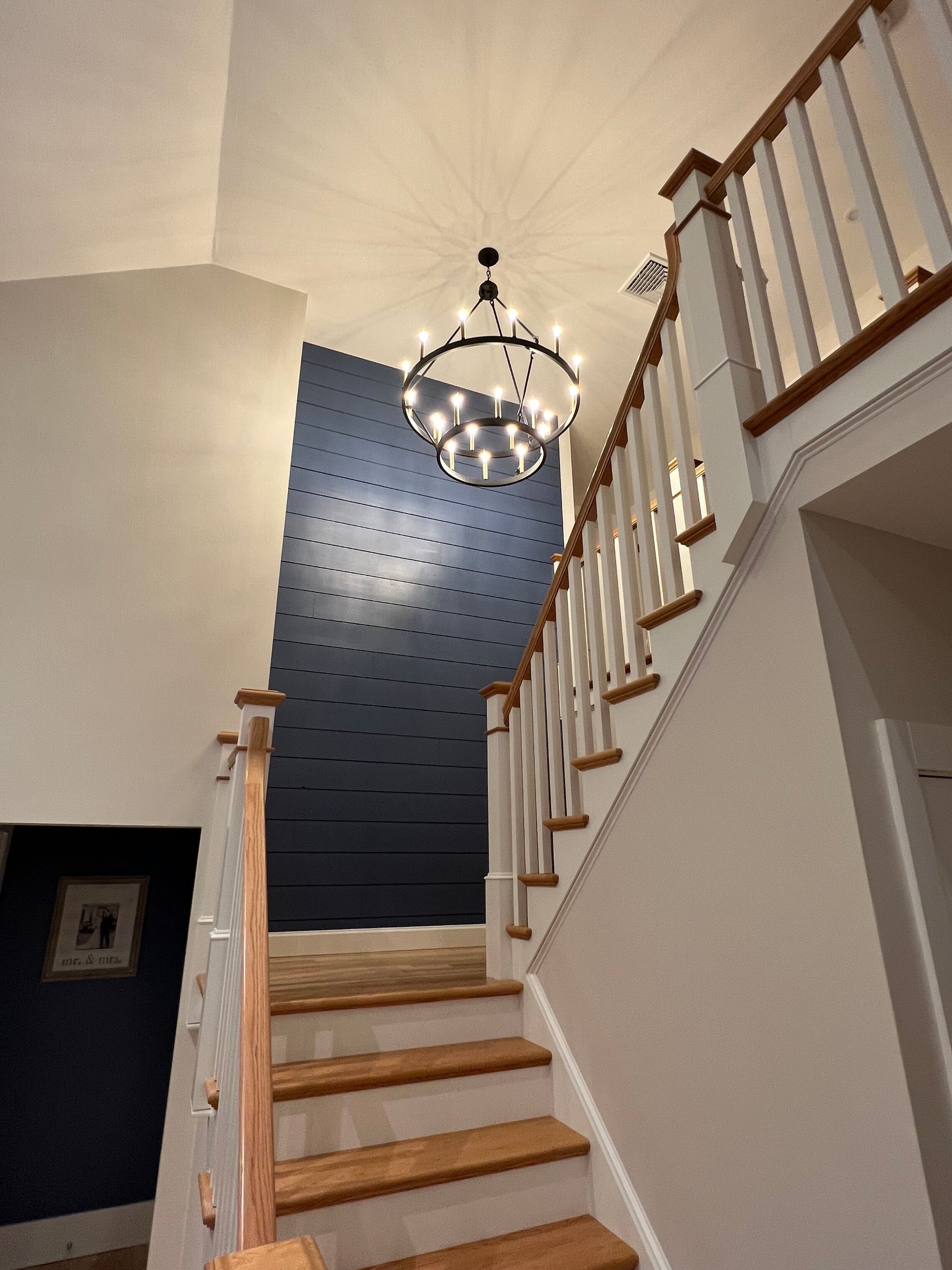 A staircase with a chandelier hanging from the ceiling