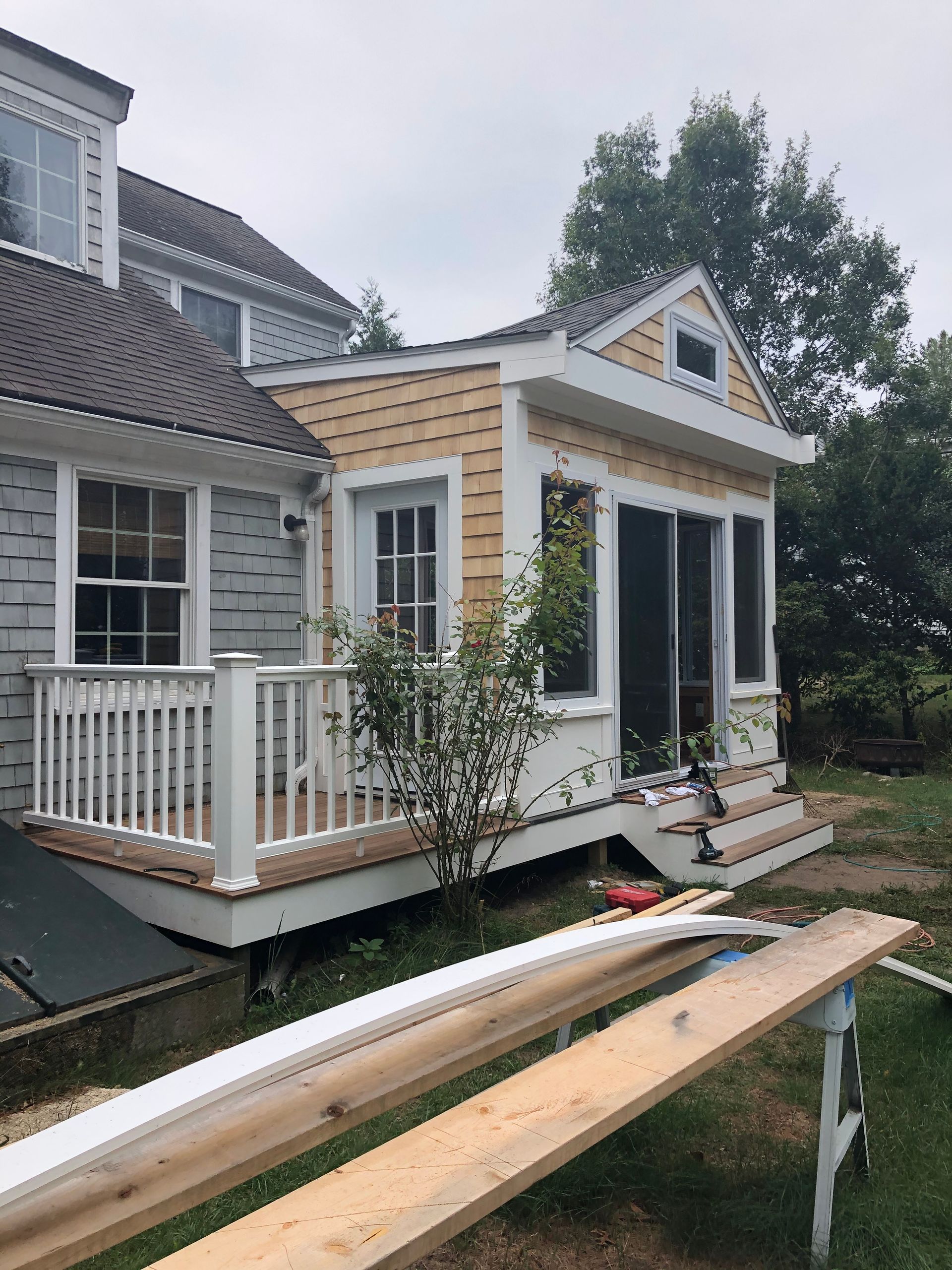 A house with a wooden bench in front of it.