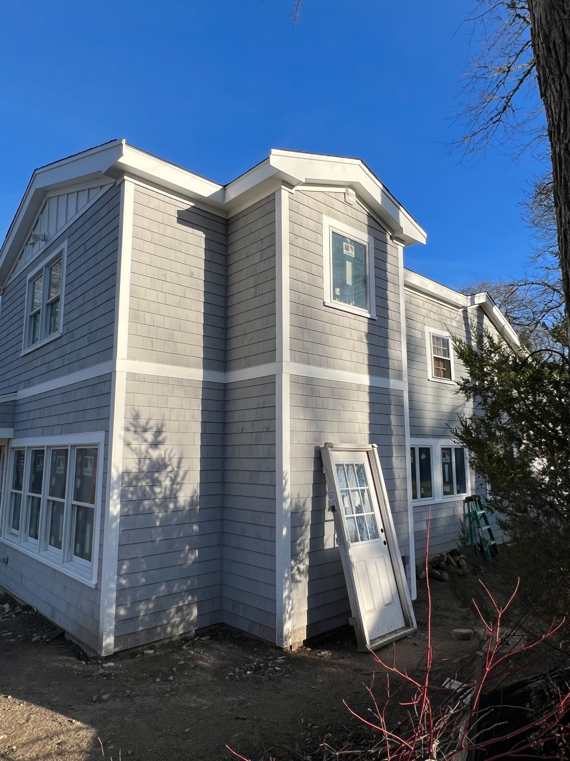 A large white house with a blue sky in the background.