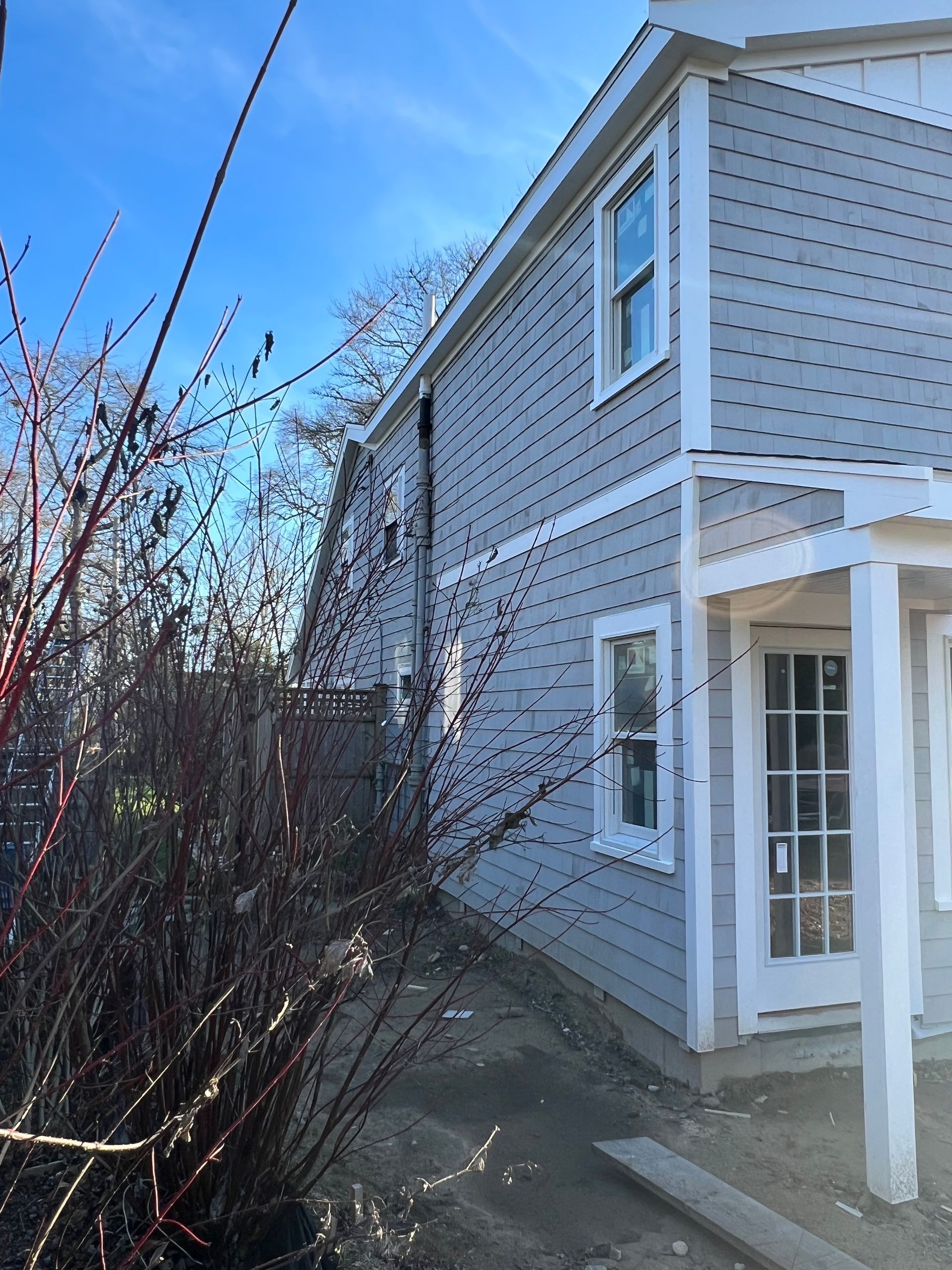 A house with a porch and a blue sky in the background