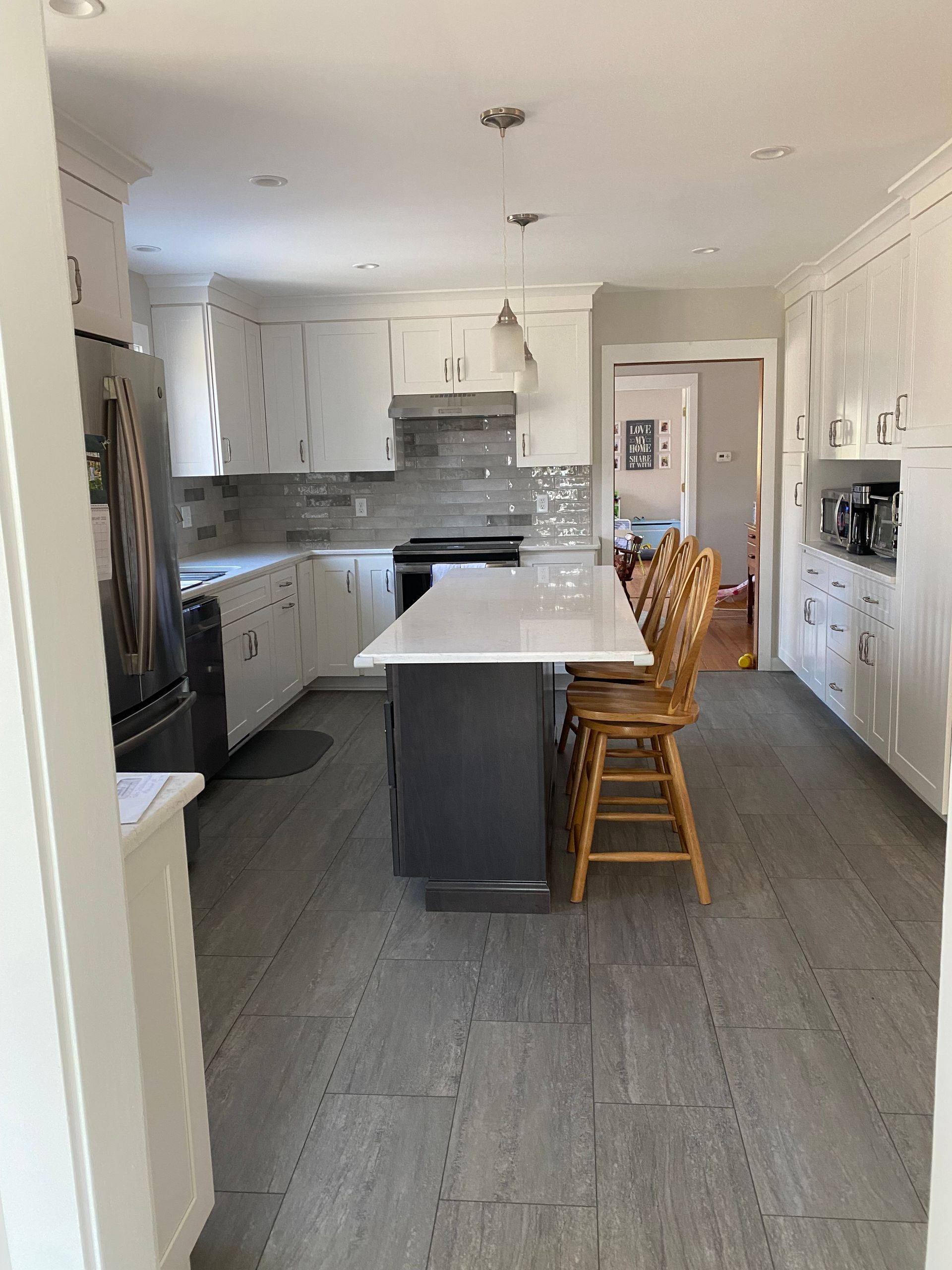 A kitchen with white cabinets and a large island in the middle.