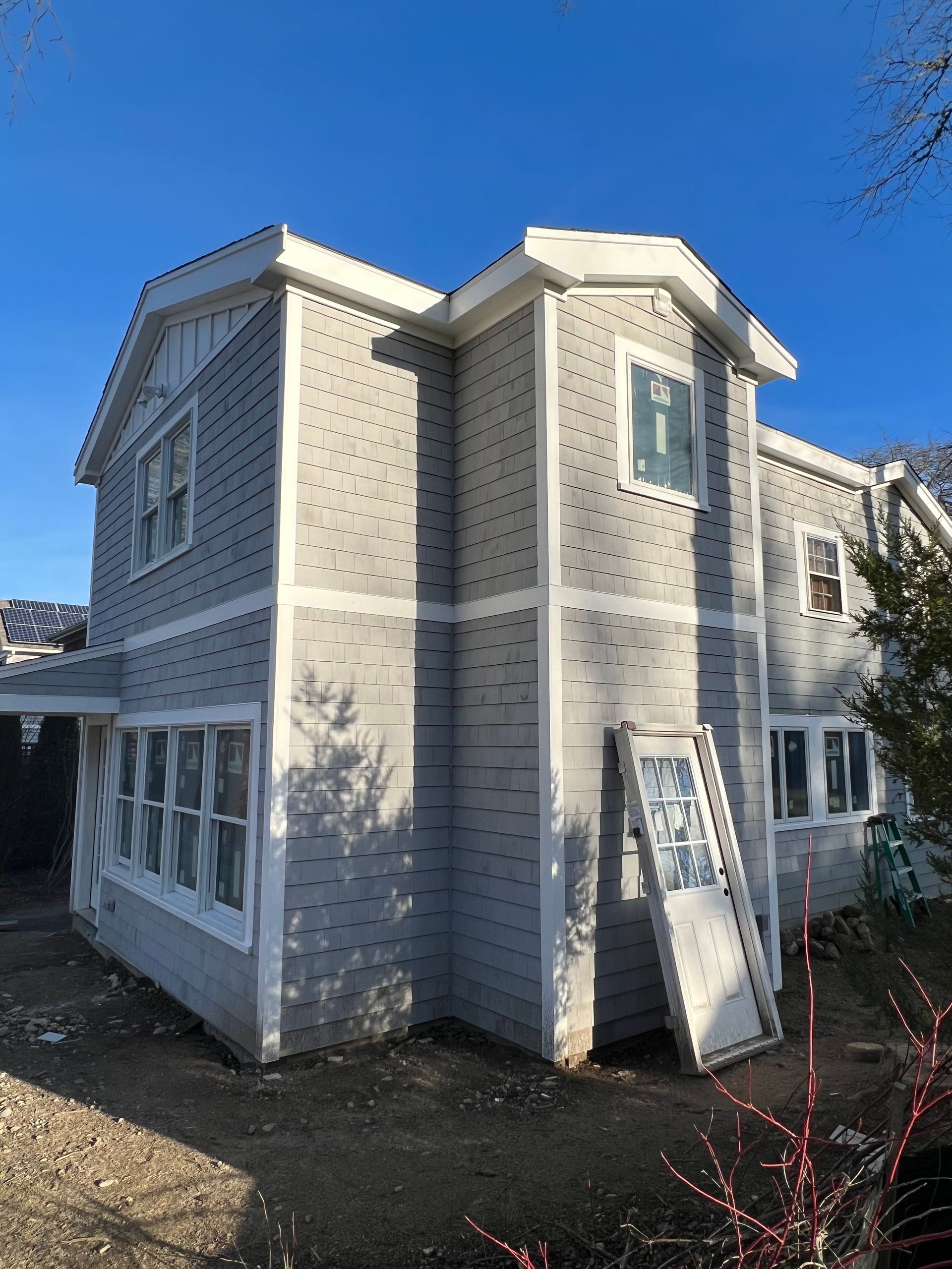 A large house with a lot of windows is being built.