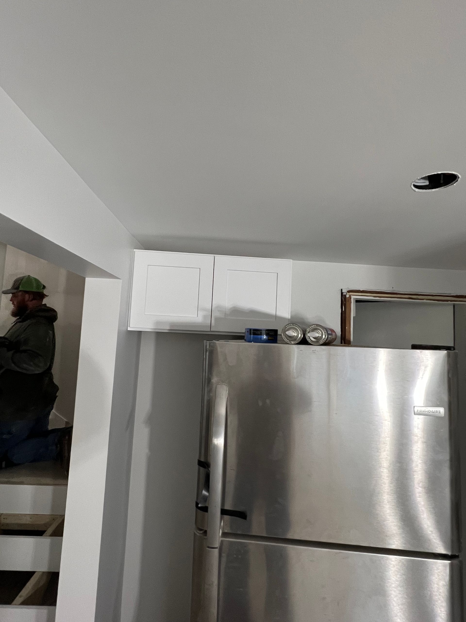 A stainless steel refrigerator in a kitchen under construction