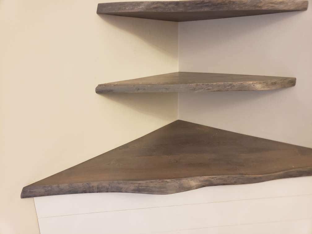 A close up of three corner shelves on a wall.