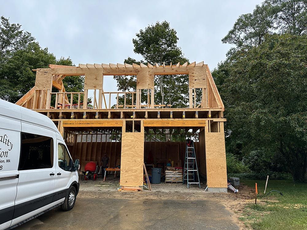 A white van is parked in front of a house under construction.