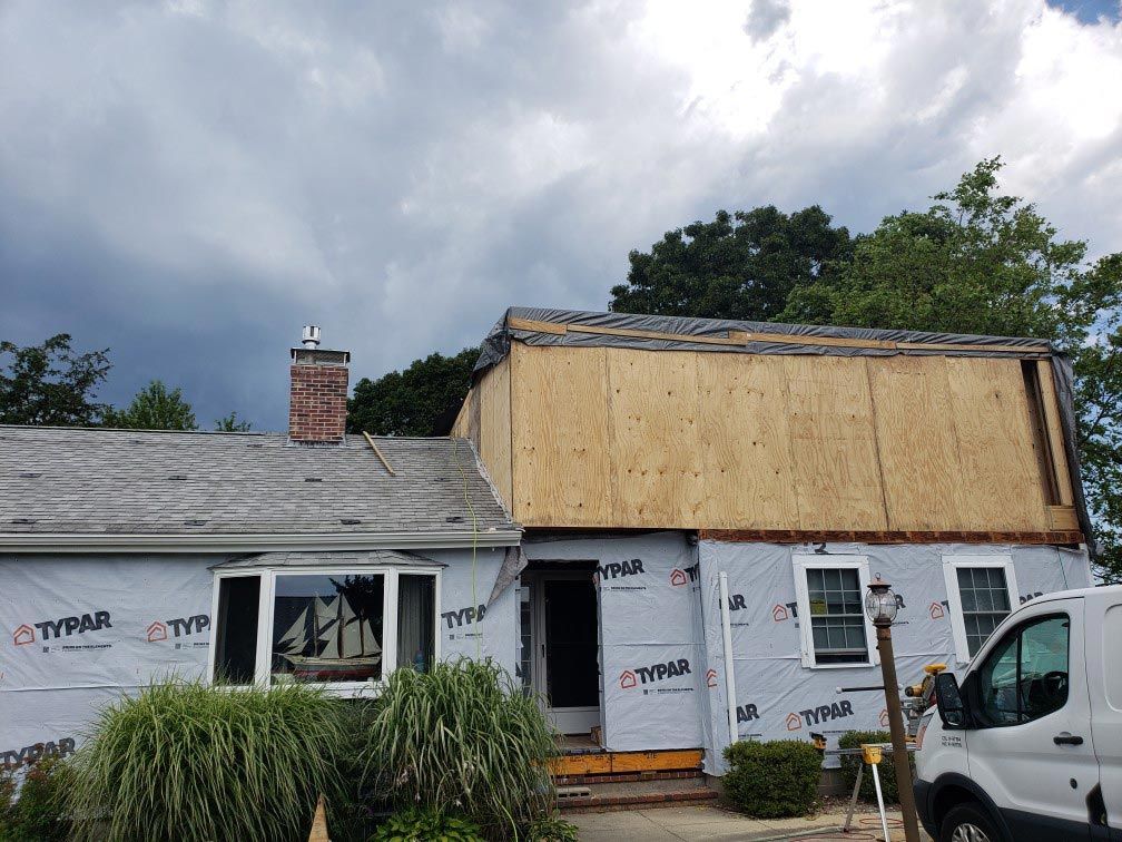 A white van is parked in front of a house that is being remodeled.