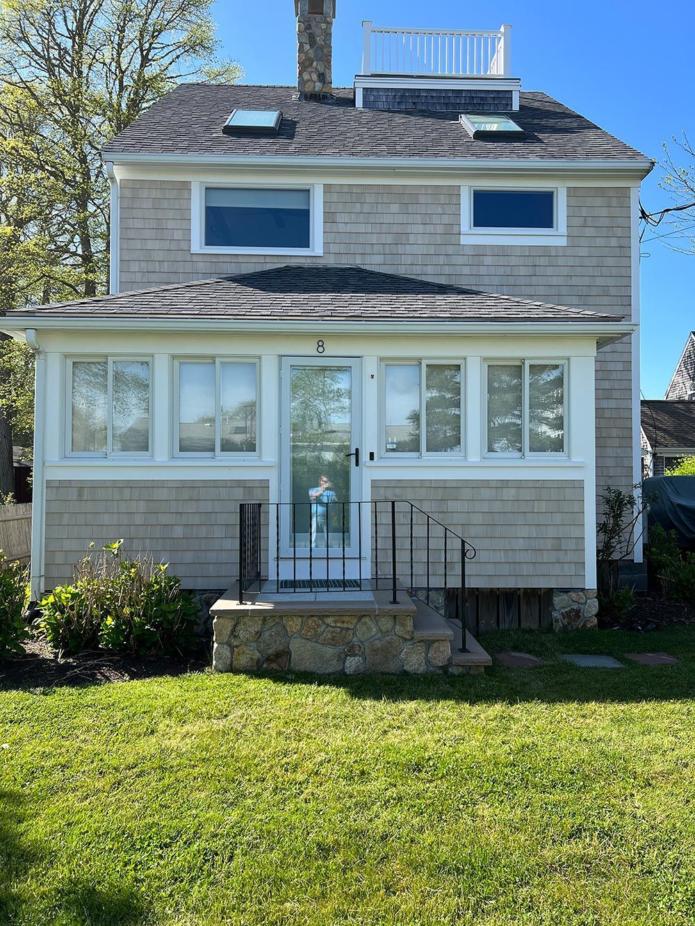 A small house with a large lawn in front of it.