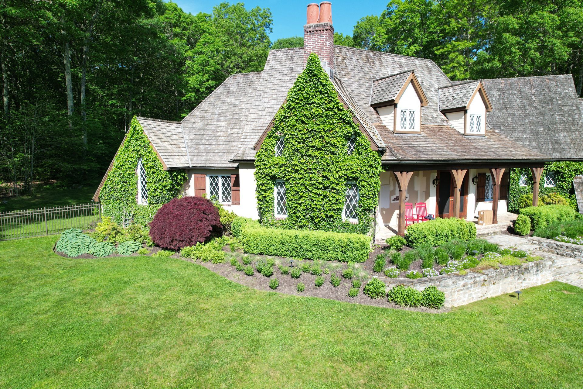 A large house with a thatched roof and a large lawn in front of it.