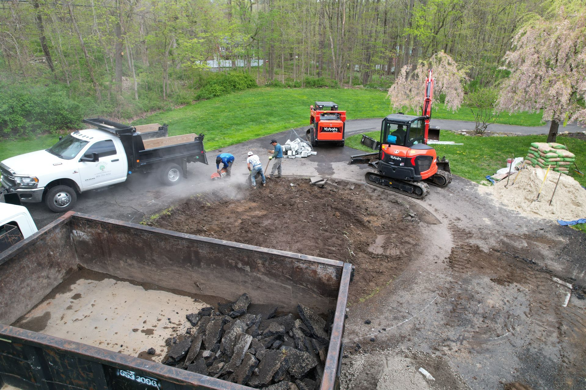 A group of construction workers are working on a dirt road.