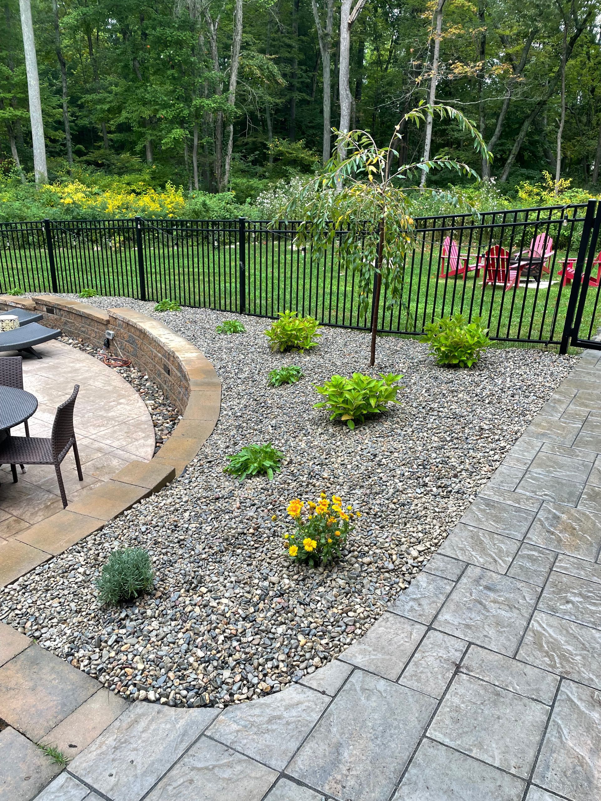 A patio with a fire pit and a fence in the backyard.