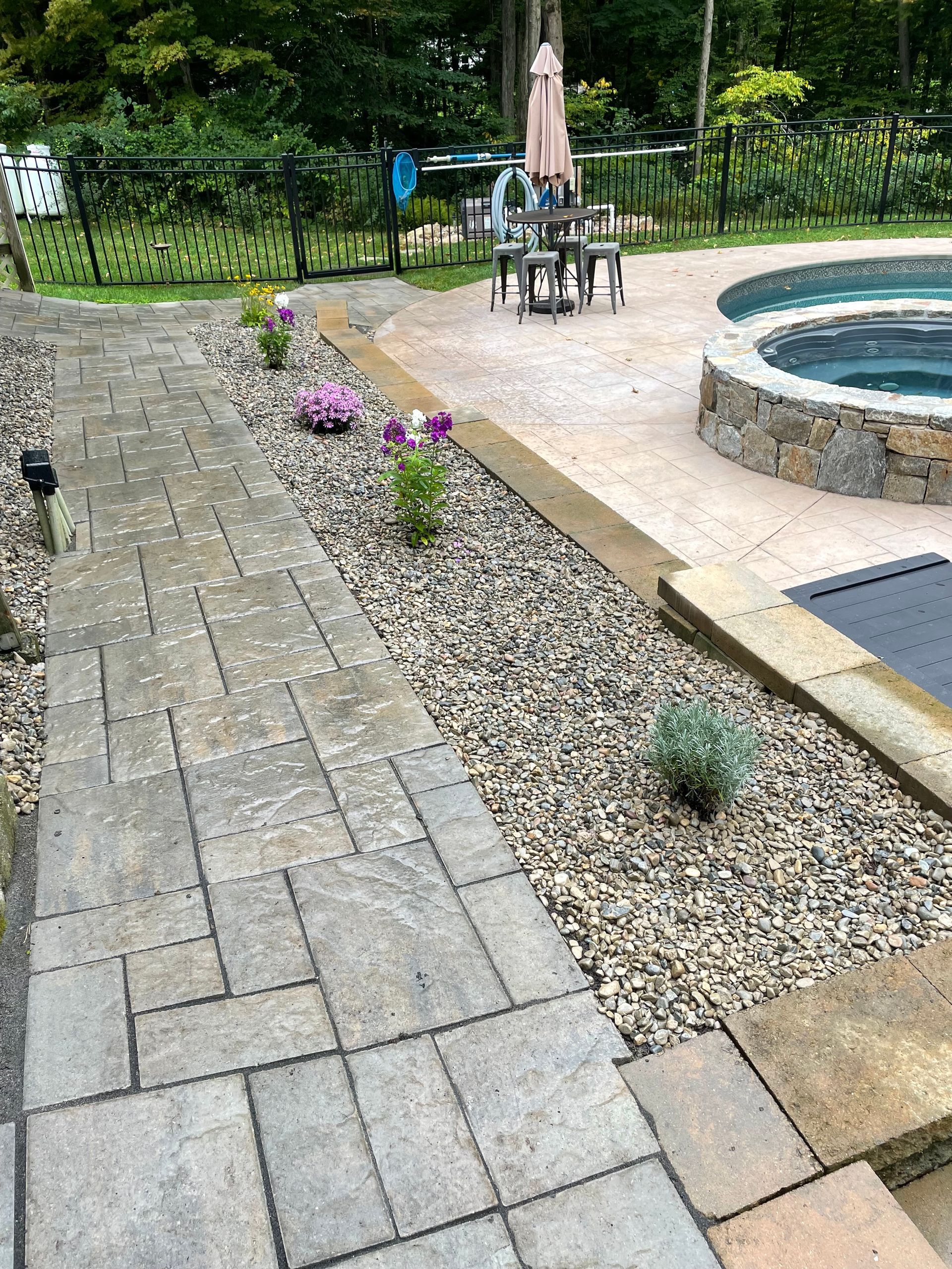 A walkway leading to a swimming pool and a hot tub.
