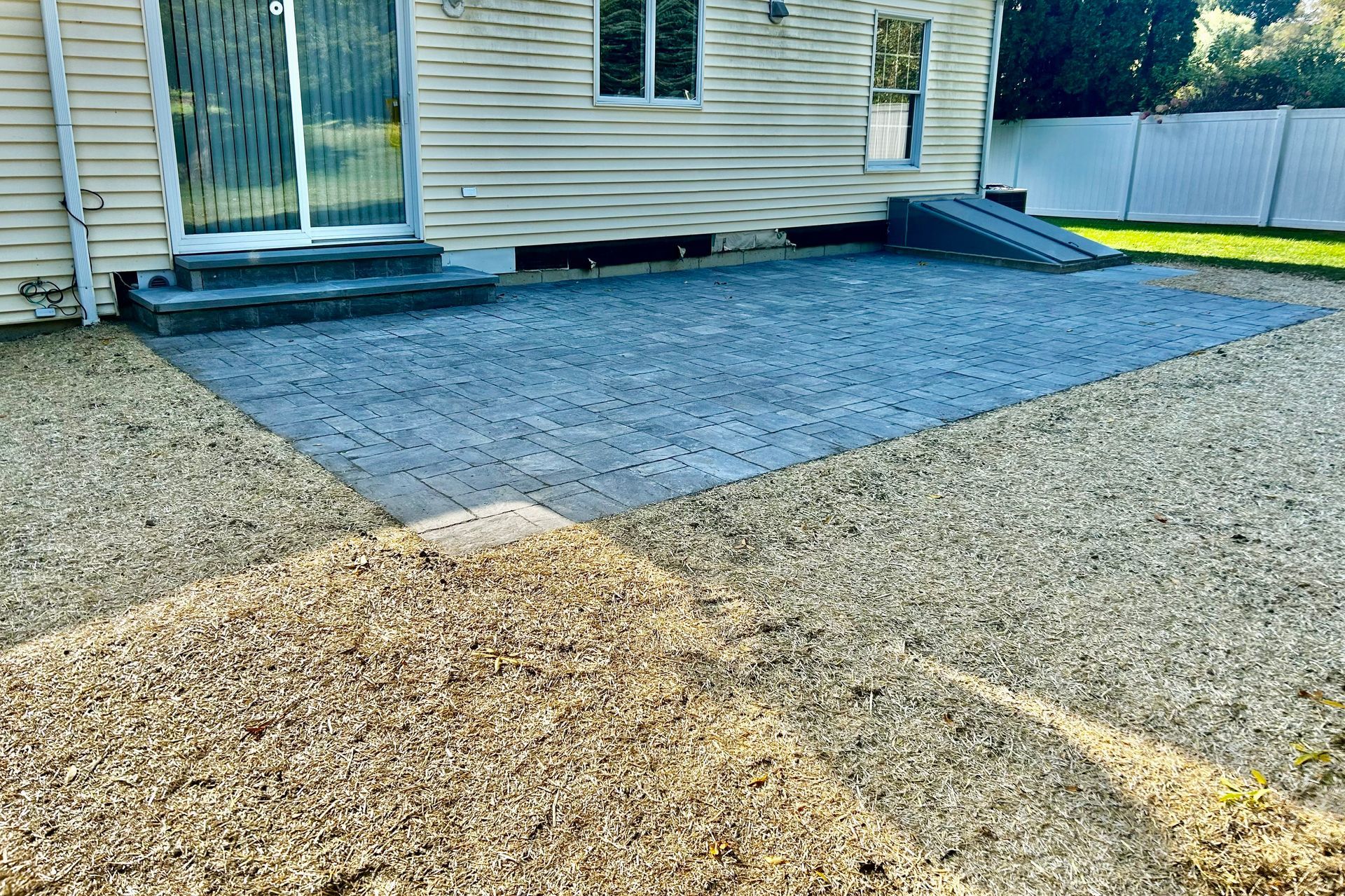 A gravel driveway in front of a house with a ramp.