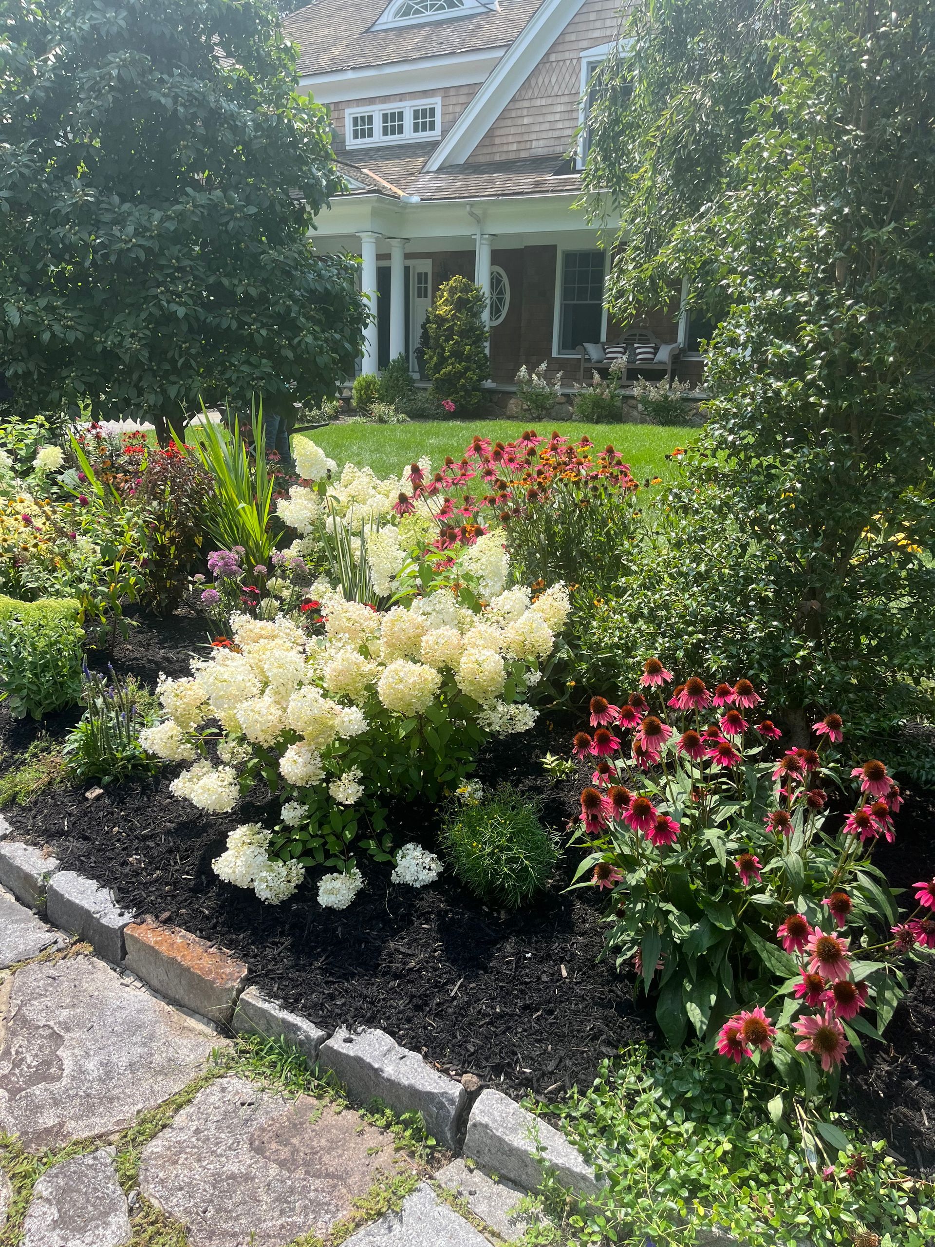 A house with a lot of flowers in front of it.