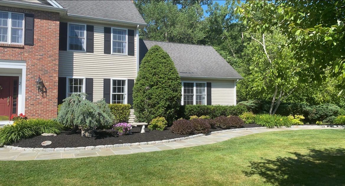 A large brick house with a large lawn in front of it.