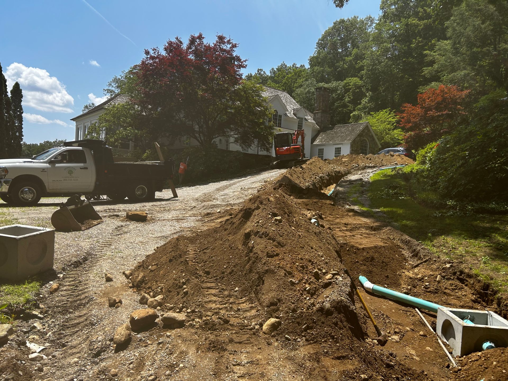 A truck is parked on the side of a dirt road next to a pile of dirt.
