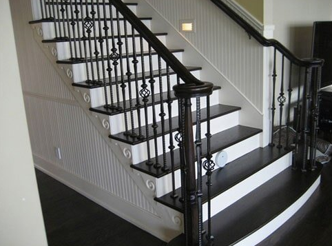 Black and white staircase with decorative metal railing.