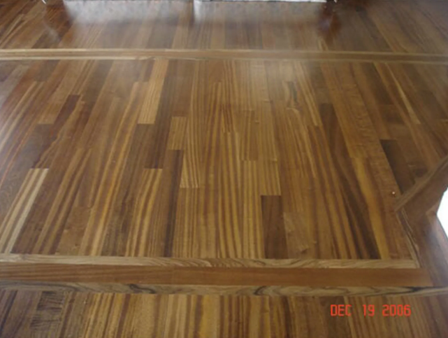 Wooden flooring with a border and a mix of light and dark brown tones.