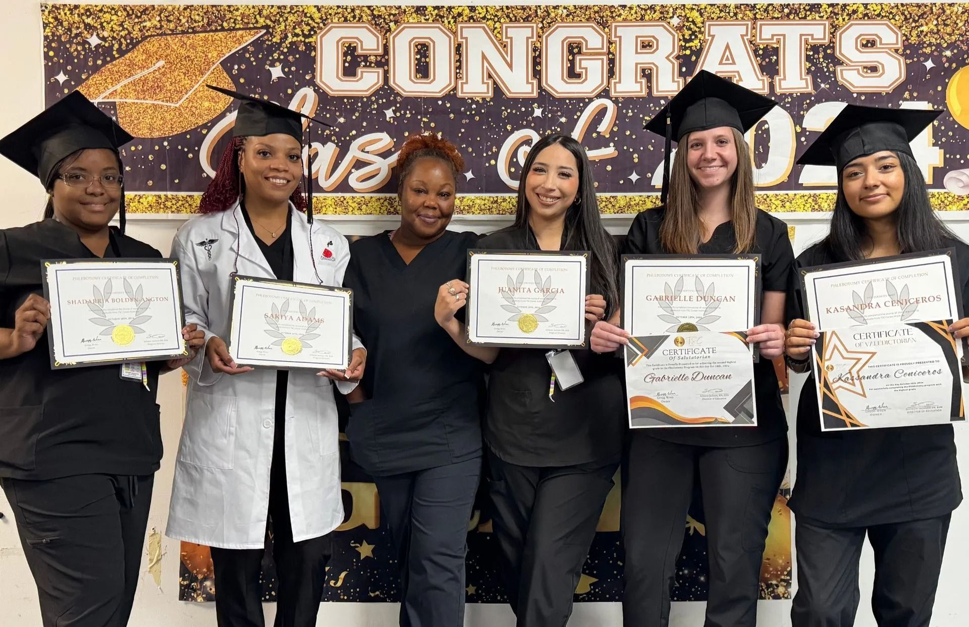 Six graduates in caps and gowns hold diplomas, smiling. "Congrats Class of 2023" banner in background.