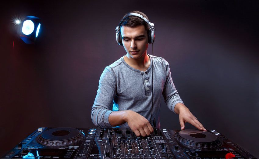 A man wearing headphones is playing music on a turntable.