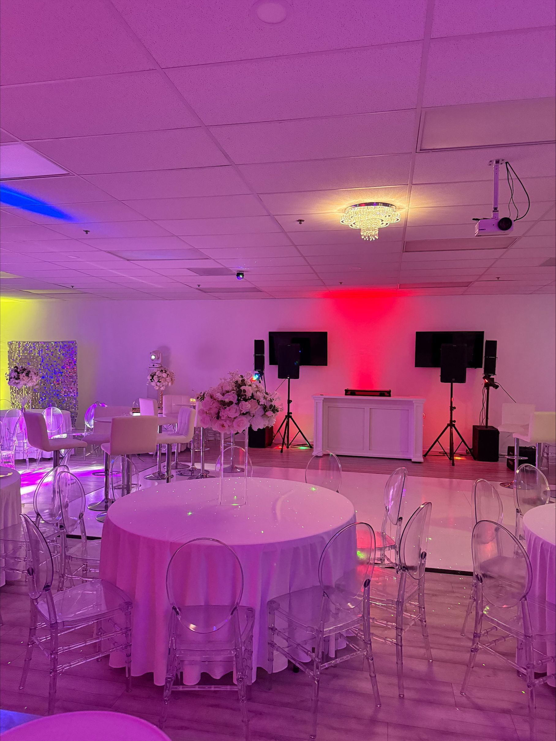 A large room with tables and chairs set up for a party.