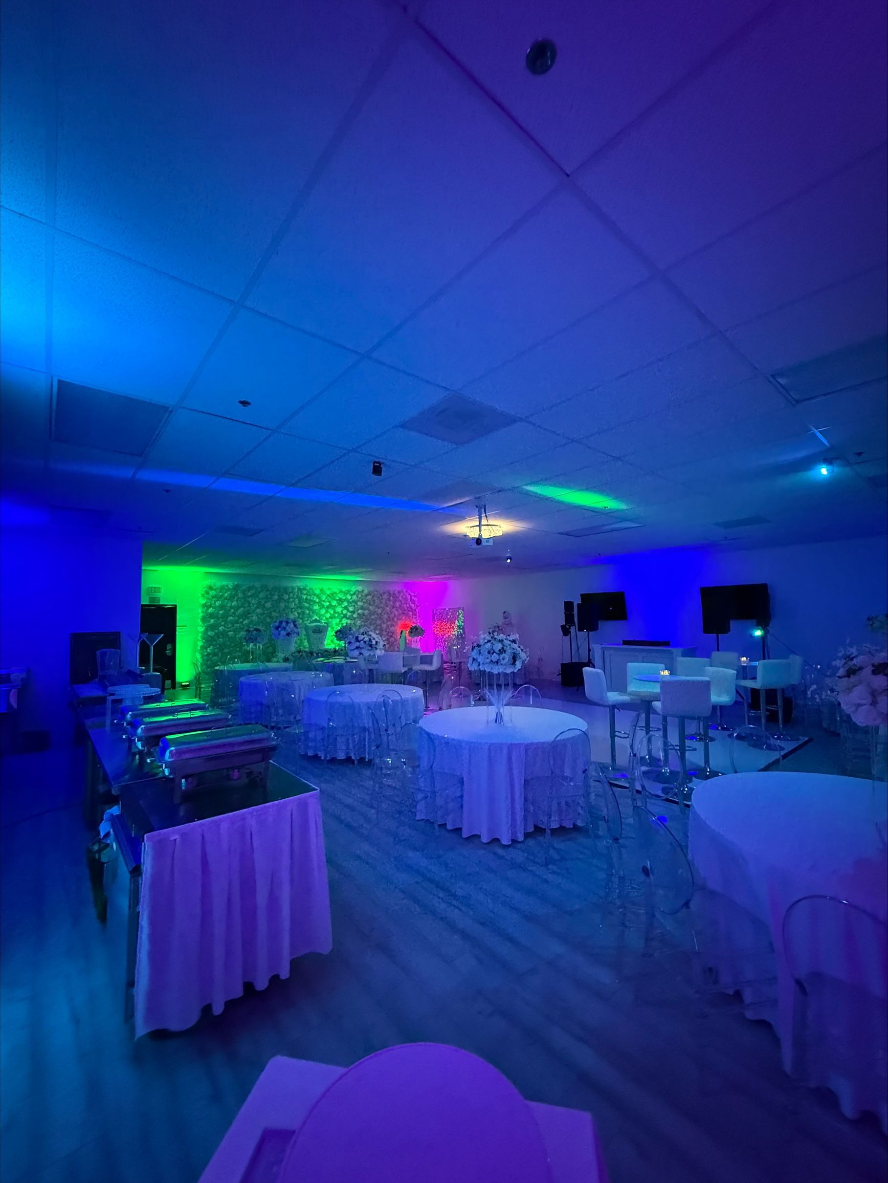 A large room with tables and chairs set up for a party.