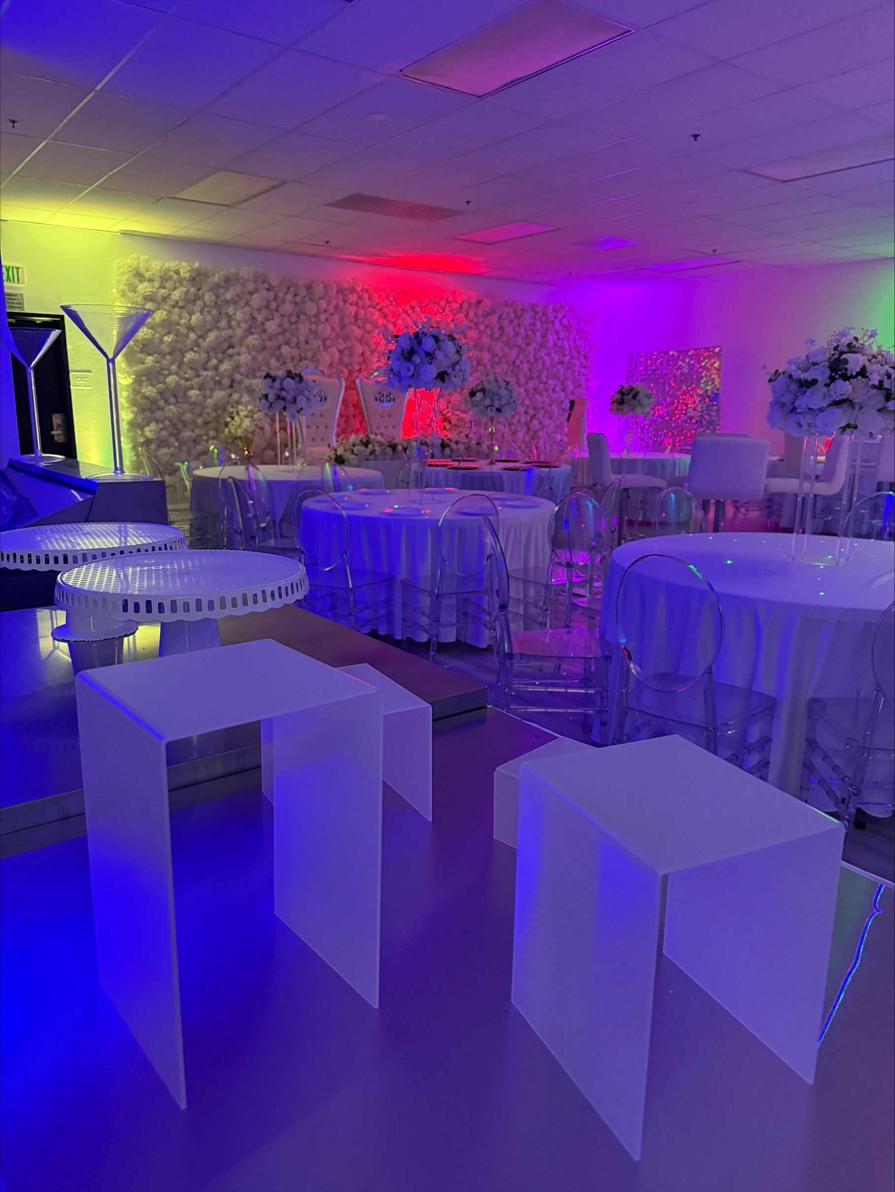 A room filled with tables and chairs and purple and blue lights.