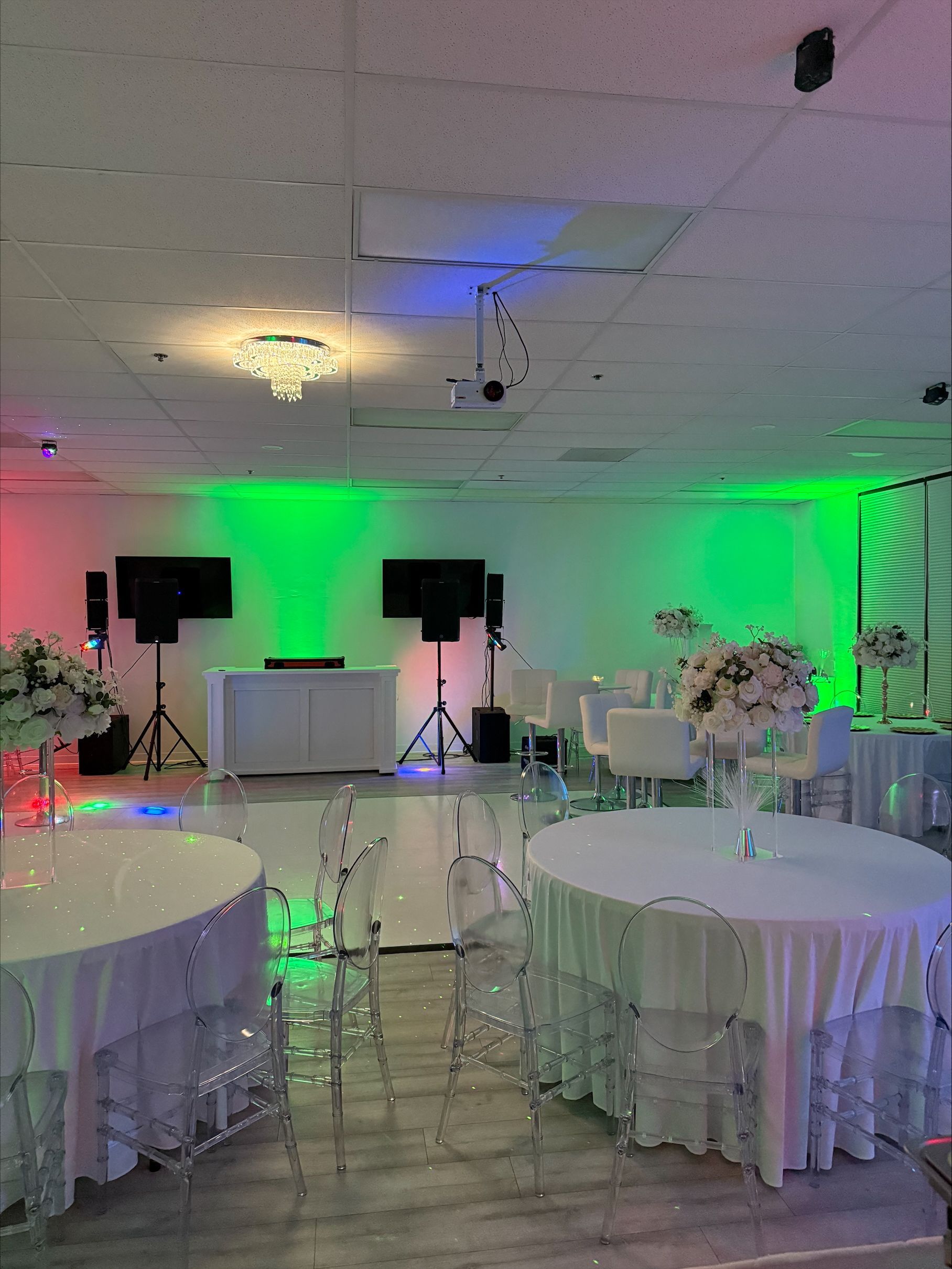 A large room with tables and chairs set up for a party.