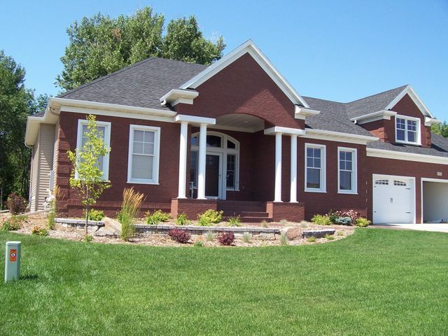A red brick house with white trim and a gray roof