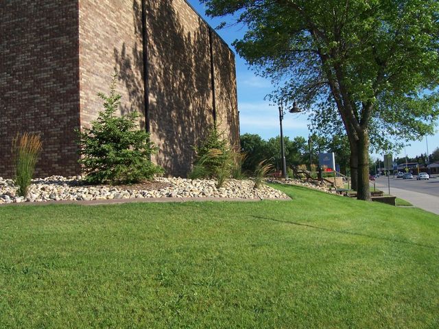 A large brick building with a lush green lawn in front of it