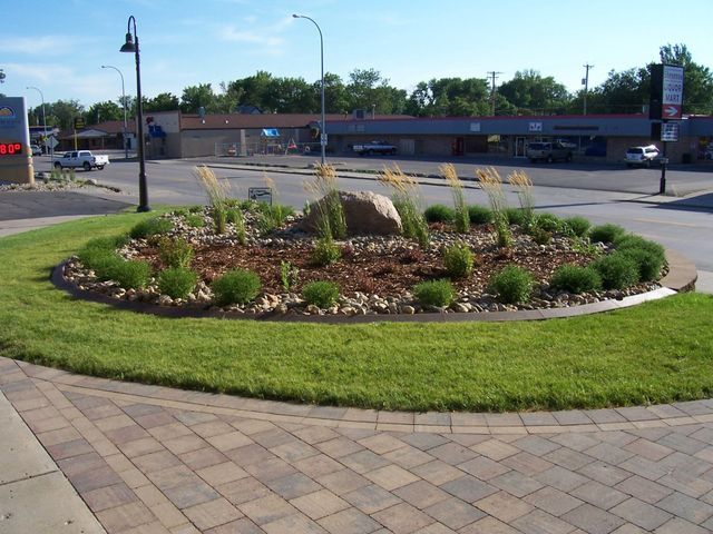 A round garden with a large rock in the middle of it