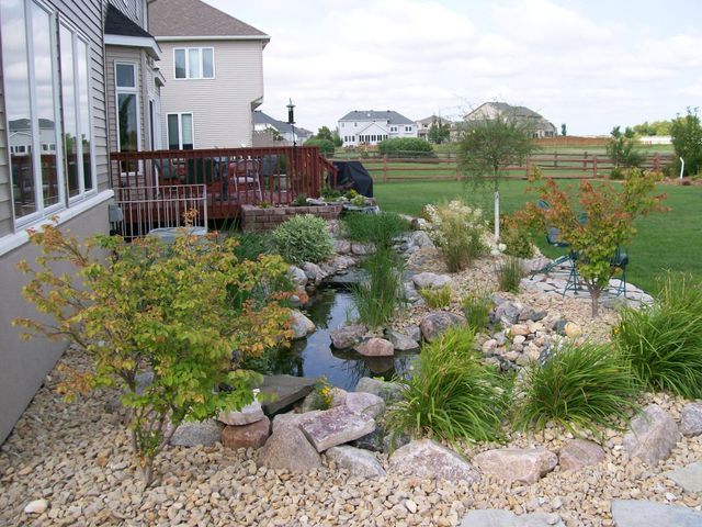 There is a pond in the backyard of a house.