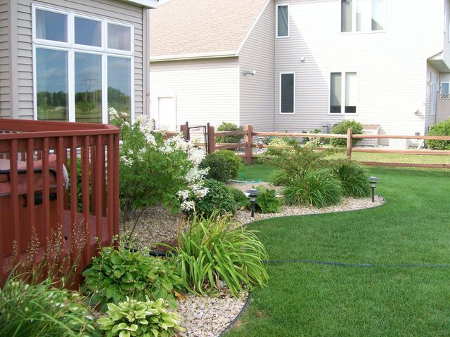 The backyard of a house with a fence and a deck