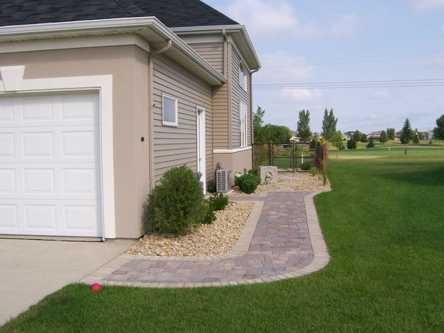 A house with a white garage door and a walkway leading to it
