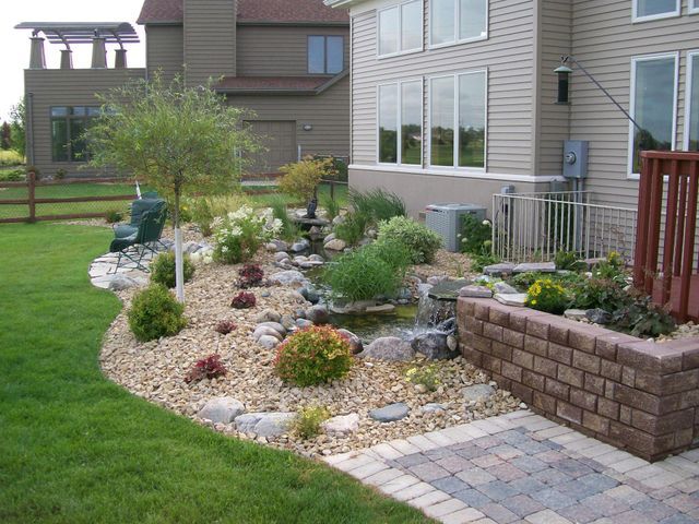A backyard with a brick walkway leading to a house